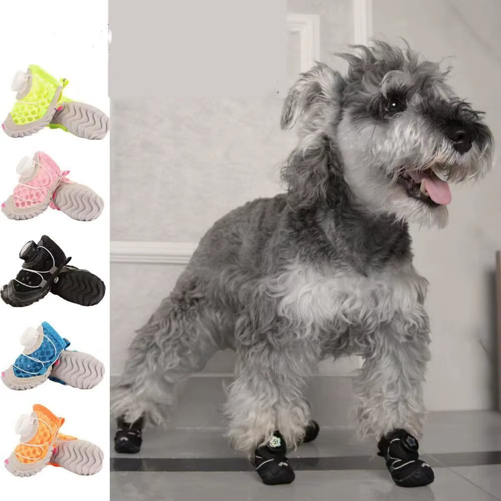 Five color options of mesh dog shoes, yellow, pink, black, blue, and orange, next to a schnauzer wearing black ones