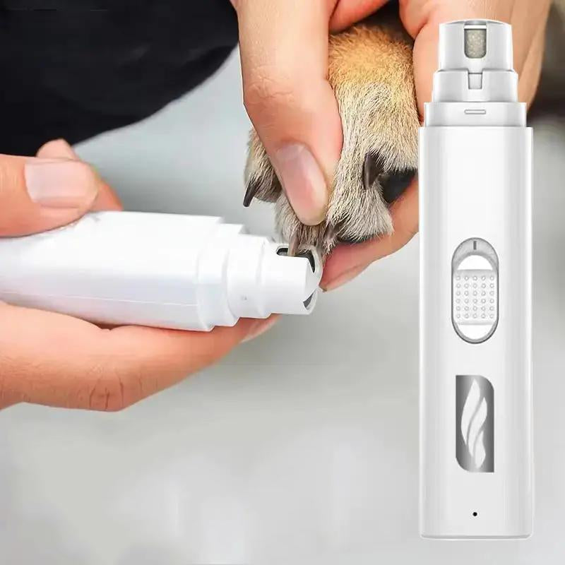White cordless nail grinder trimming a dog's paw nail with a rotating sanding wheel visible