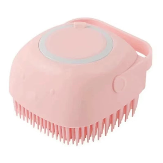 Pink silicone bath brush shown at an angle with its round shampoo dispenser lid and wrist strap