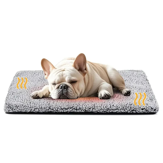French Bulldog sleeping on a gray fleece self-heating pet pad with heat-wave icons showing warmth
