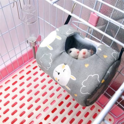 Two small rodents peeking out of the entrance hole of a gray sheep print hammock bed