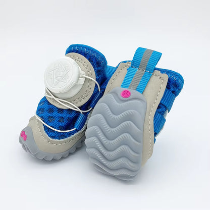 Pair of blue mesh dog shoes with a white dial reel closure showing the textured sole underneath