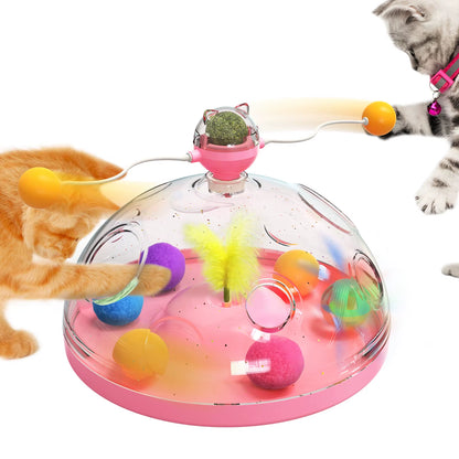 Pink version of the spinning dome cat toy with two cats batting at the swinging orange balls