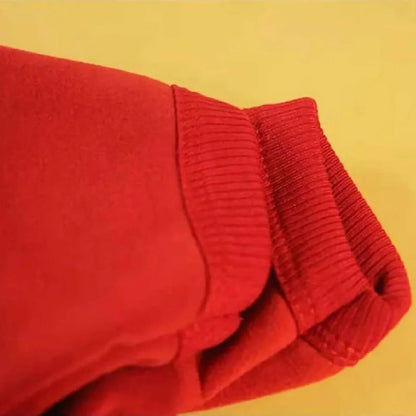 Close-up of folded red dog hoodie fabric showing the ribbed elastic cuff trim detail