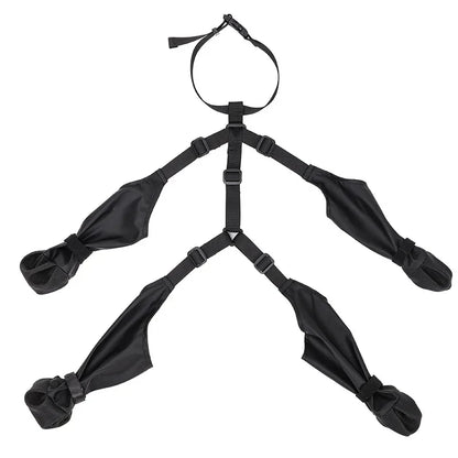 Set of four black PawGuard dog boots with adjustable straps laid out and connected by a harness-style strap system