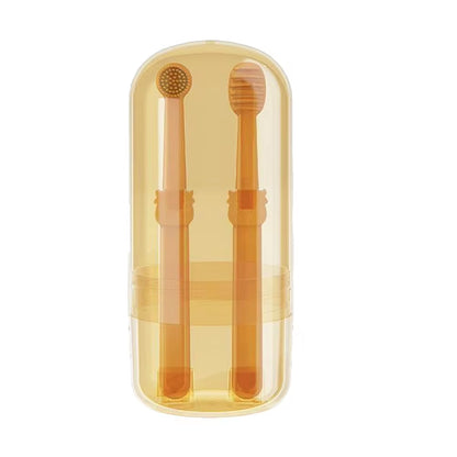 Two orange silicone toothbrushes standing upright in their clear plastic travel case