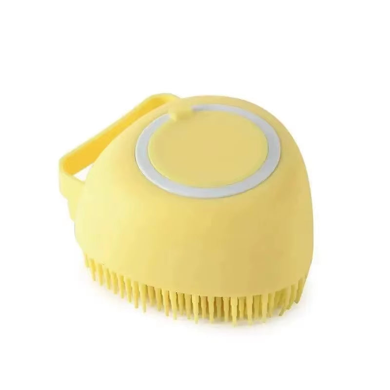 Silicone bath brush held in a hand to show its compact size and finger loop strap