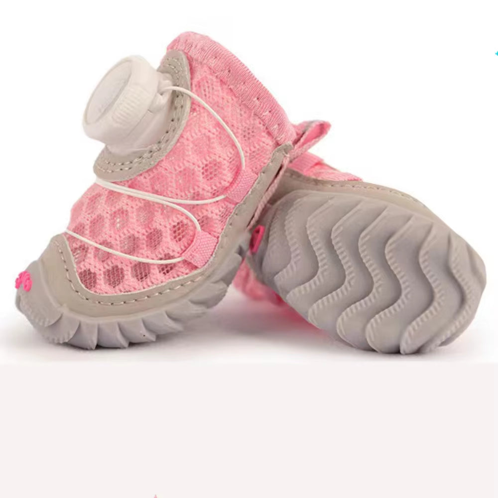 Pair of pink mesh dog shoes with a white dial reel closure and wave-pattern rubber sole