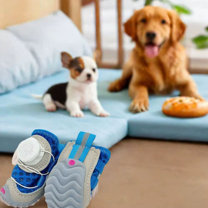 Blue mesh dog shoe held up in the foreground with a puppy and adult dog resting on a blue mat