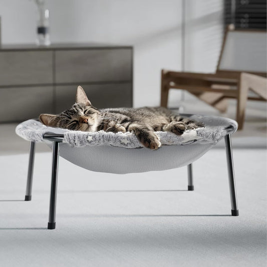 Tabby cat sleeping in a gray elevated hammock cat bed with metal legs on a living room floor