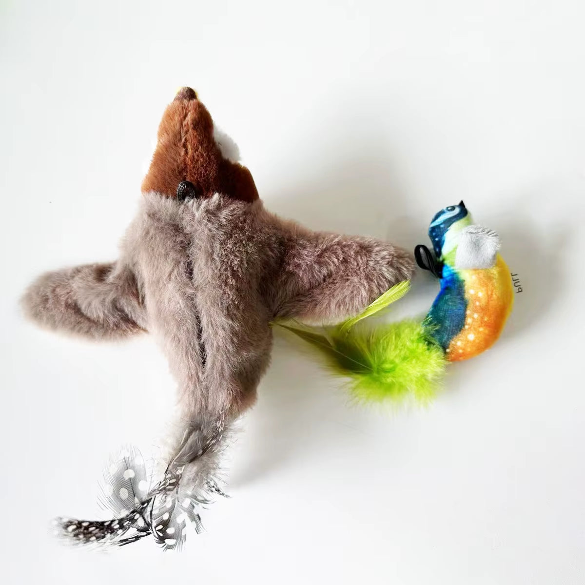Blue and brown FlutterChirp plush bird cat toys with feather tails shown side by side from above